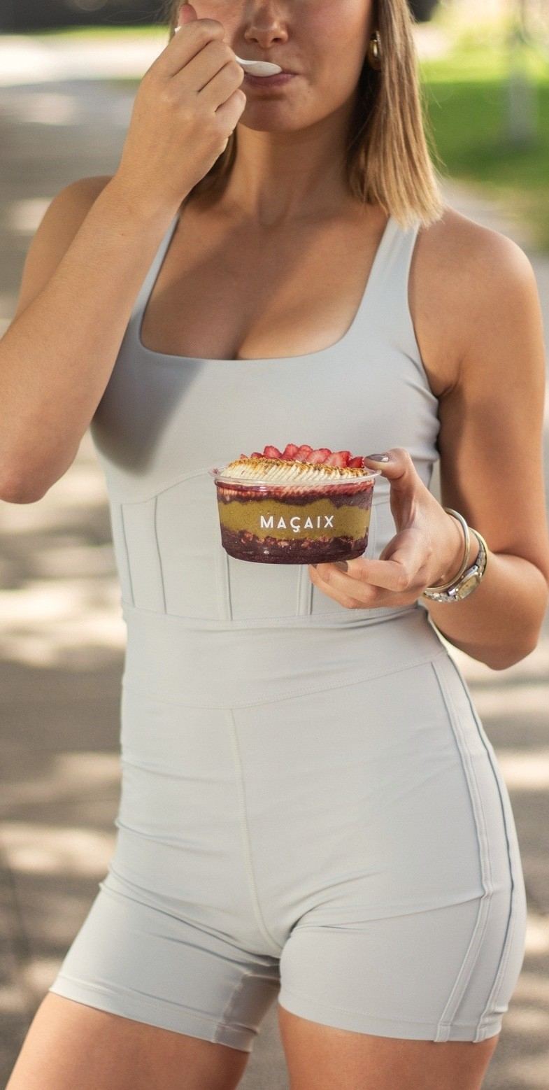 A customer eating an açaí bowl outdoors